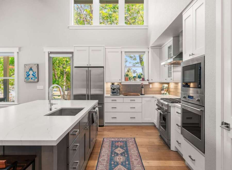 Experience modern luxury in this stunning kitchen, featuring a spacious island with a deep sink and sleek countertops.