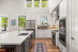Experience modern luxury in this stunning kitchen, featuring a spacious island with a deep sink and sleek countertops.