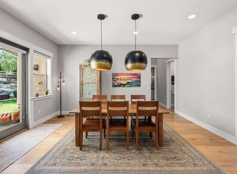 This elegant dining room features a large wooden table with six chairs, perfect for family gatherings.
