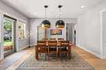 This elegant dining room features a large wooden table with six chairs, perfect for family gatherings.