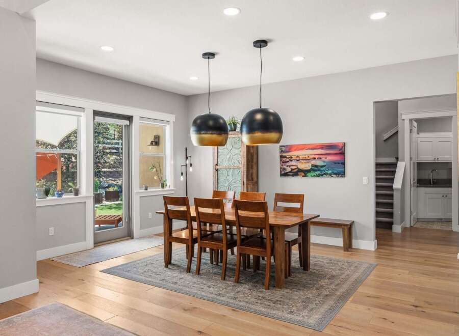 This spacious dining room features a large wooden table with six chairs, perfect for family gatherings.