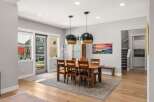 This spacious dining room features a large wooden table with six chairs, perfect for family gatherings.