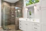 Experience luxury in this stunning bathroom featuring a spacious glass-enclosed shower with elegant tilework and modern fixtures.