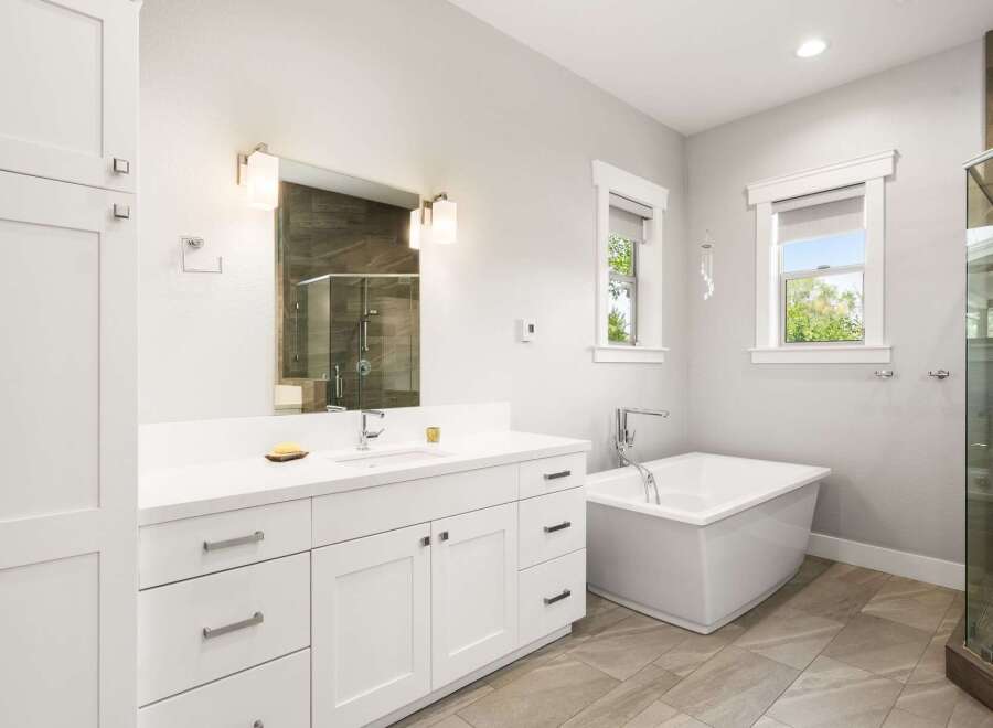 Experience luxury in this modern bathroom, featuring a freestanding soaking tub and a spacious glass-enclosed shower with elegant tilework.