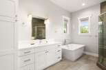 Experience luxury in this modern bathroom, featuring a freestanding soaking tub and a spacious glass-enclosed shower with elegant tilework.