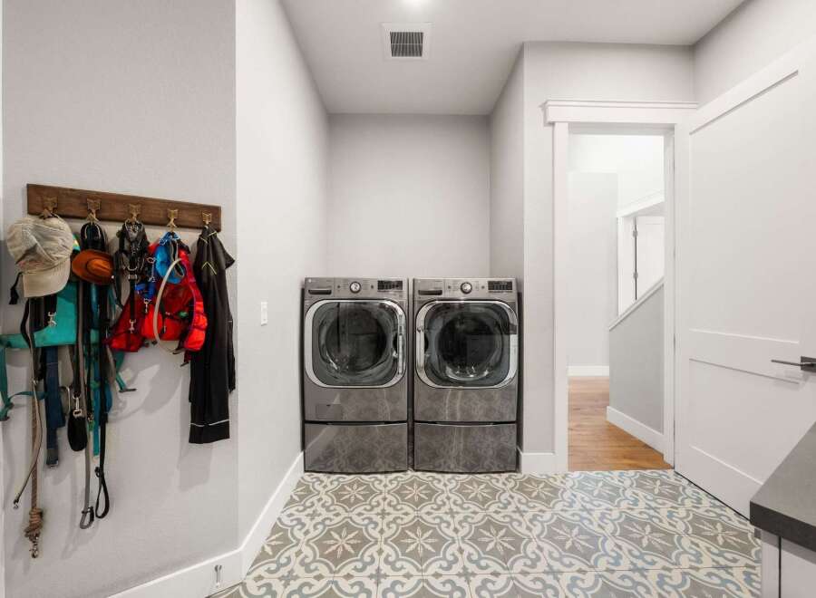 This laundry room features a pair of modern LG front-load washers and dryers, perfect for handling large loads.