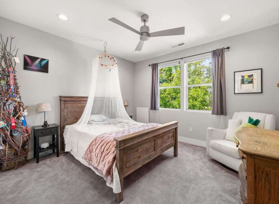 This charming bedroom features a cozy wooden bed adorned with a sheer canopy, creating a whimsical atmosphere.