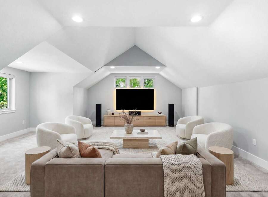 Experience ultimate comfort and style in this modern living room, featuring plush white accent chairs and a spacious sectional sofa perfect for gatherings.