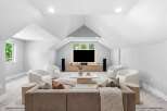 Experience ultimate comfort and style in this modern living room, featuring plush white accent chairs and a spacious sectional sofa perfect for gatherings.