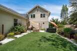 Enjoy outdoor living in this backyard oasis featuring a spacious artificial turf lawn perfect for recreation.