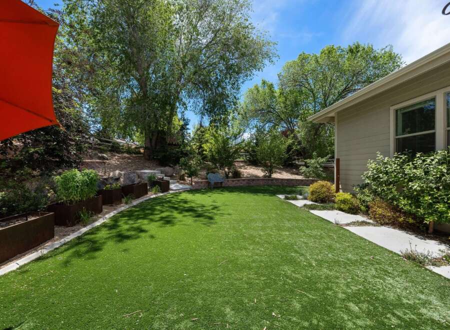 Discover this stunning backyard oasis featuring a lush, low-maintenance artificial turf lawn perfect for relaxation and play.