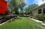 Discover this stunning backyard oasis featuring a lush, low-maintenance artificial turf lawn perfect for relaxation and play.