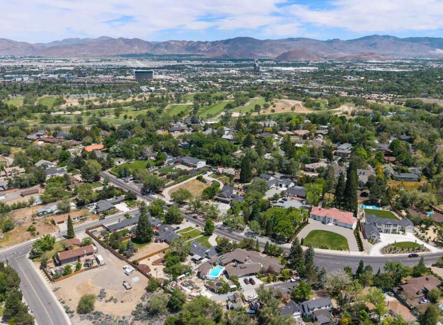 Discover this stunning aerial view showcasing a picturesque neighborhood with lush greenery and well-maintained homes.