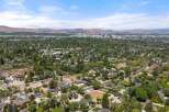 Discover this stunning property nestled in a lush, tree-filled neighborhood with a vibrant cityscape in the distance.