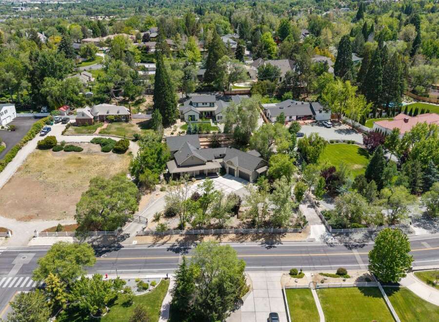 Discover this stunning estate featuring a spacious, modern home with a three-car garage, nestled amidst mature trees and lush landscaping.