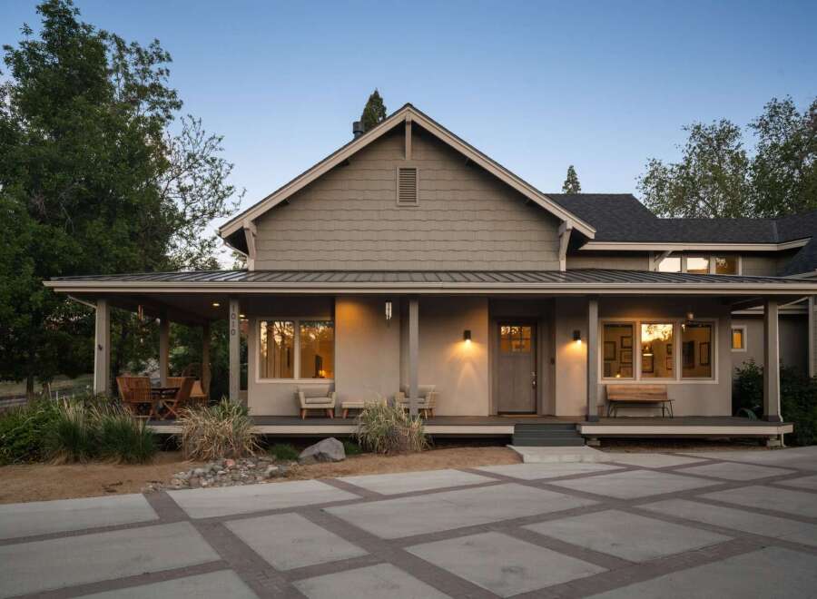 This charming home features a welcoming covered porch with ample seating, perfect for enjoying the outdoors.