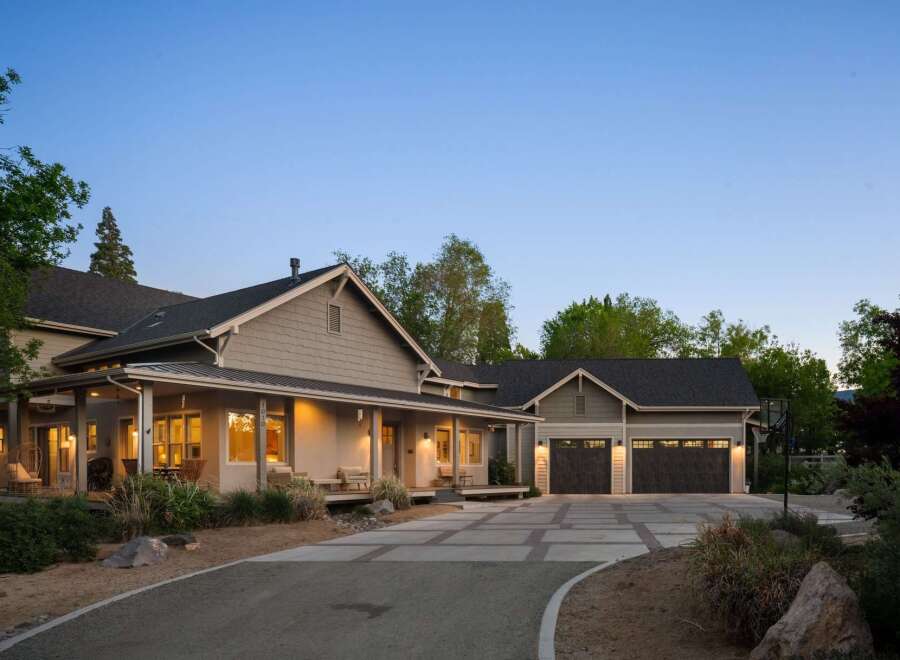 This stunning home features a welcoming covered porch with comfortable seating, perfect for enjoying the serene surroundings.
