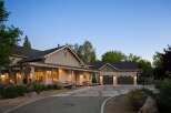 This stunning home features a welcoming covered porch with comfortable seating, perfect for enjoying the serene surroundings.