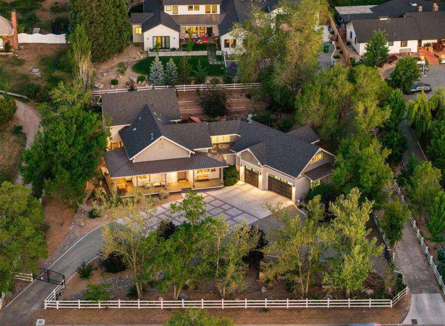 Experience luxury living in this stunning estate, featuring a spacious main residence with a welcoming covered porch and a detached three-car garage.