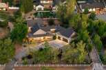 Experience luxury living in this stunning estate, featuring a spacious main residence with a welcoming covered porch and a detached three-car garage.
