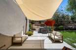 Enjoy outdoor living with this spacious patio featuring comfortable seating and a relaxing hot tub, perfect for unwinding.