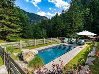 Escape to this serene mountain retreat featuring a stunning private pool surrounded by lush greenery and majestic pine forests.