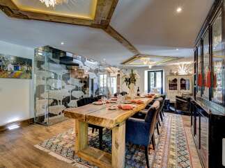 Experience luxurious dining in this exquisite home, featuring a stunning live-edge wooden dining table that serves as the centerpiece of the room.