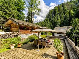 Experience the ultimate mountain retreat in this charming wooden chalet, nestled amidst lush greenery and offering breathtaking views of snow-capped peaks.