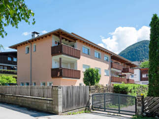 Discover this charming multi-story building featuring multiple balconies with wooden railings, perfect for enjoying the outdoors.