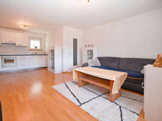 Discover this charming open-concept living space, seamlessly blending a modern kitchen with a cozy living area.
