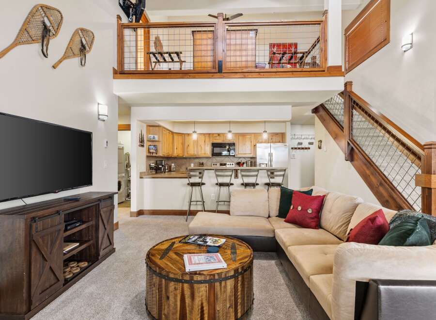 Experience rustic charm in this inviting living space, featuring a large sectional sofa perfect for gatherings and a unique barrel-style coffee table.