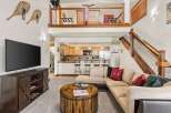 Experience rustic charm in this inviting living space, featuring a large sectional sofa perfect for gatherings and a unique barrel-style coffee table.