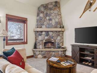 Cozy up by the stunning floor-to-ceiling stone fireplace, perfect for chilly mountain evenings.