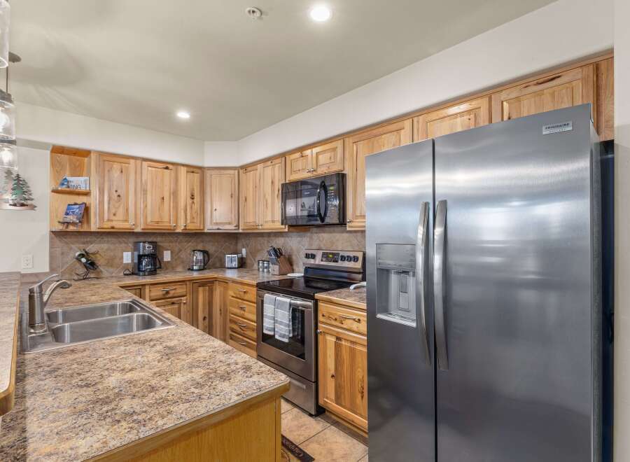 Discover this charming kitchen featuring warm, natural wood cabinetry and a spacious stainless steel refrigerator.