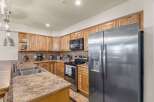 Discover this charming kitchen featuring warm, natural wood cabinetry and a spacious stainless steel refrigerator.