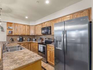 Discover this charming kitchen featuring warm, natural wood cabinetry and a spacious stainless steel refrigerator.