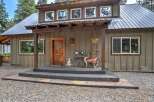 Charming rustic cabin with a welcoming wooden porch and a cozy seating area.