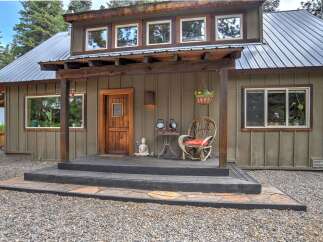 Charming rustic cabin with a welcoming wooden porch and a cozy seating area.
