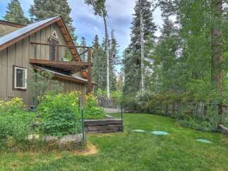 Nestled amidst a serene forest, this charming home offers a tranquil retreat with its rustic exterior and lush surrounding greenery.