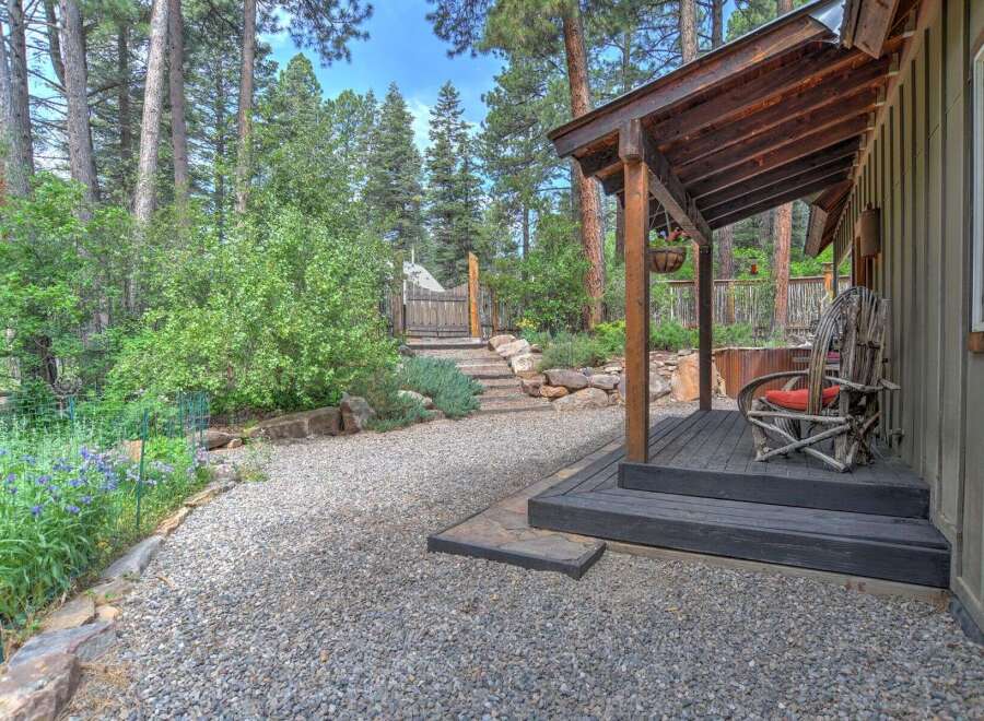Experience rustic charm with this inviting porch, featuring a unique twig chair perfect for enjoying the serene, wooded surroundings.