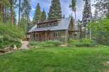 Nestled amidst tall pines, this charming cabin offers a serene retreat with a rustic aesthetic.