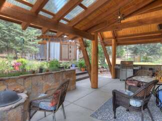 Enjoy outdoor living in this covered patio space, complete with a gas grill and comfortable seating.