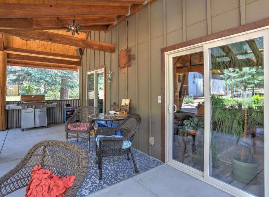 Enjoy outdoor living on this covered patio, complete with a built-in grill and comfortable seating.