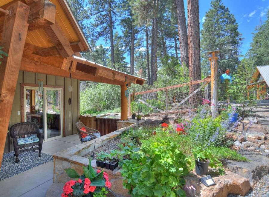 Enjoy outdoor living with this charming property featuring a covered patio, a relaxing hot tub, and a beautifully landscaped garden.