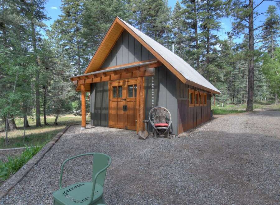 Discover this charming cabin nestled amongst tall pine trees, offering a serene retreat.