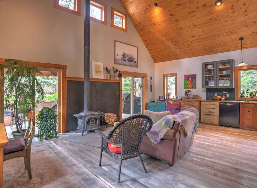 Experience rustic charm in this open-concept living space, featuring a striking wood-burning stove as the focal point.