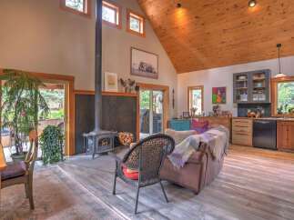 Experience rustic charm in this open-concept living space, featuring a striking wood-burning stove as the focal point.