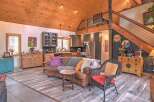 Experience rustic charm in this open-concept living space, featuring a vaulted wood-paneled ceiling and a cozy seating area.