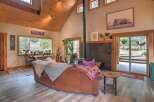Experience rustic charm in this inviting living room, featuring a vaulted wood-paneled ceiling and a cozy wood-burning stove.