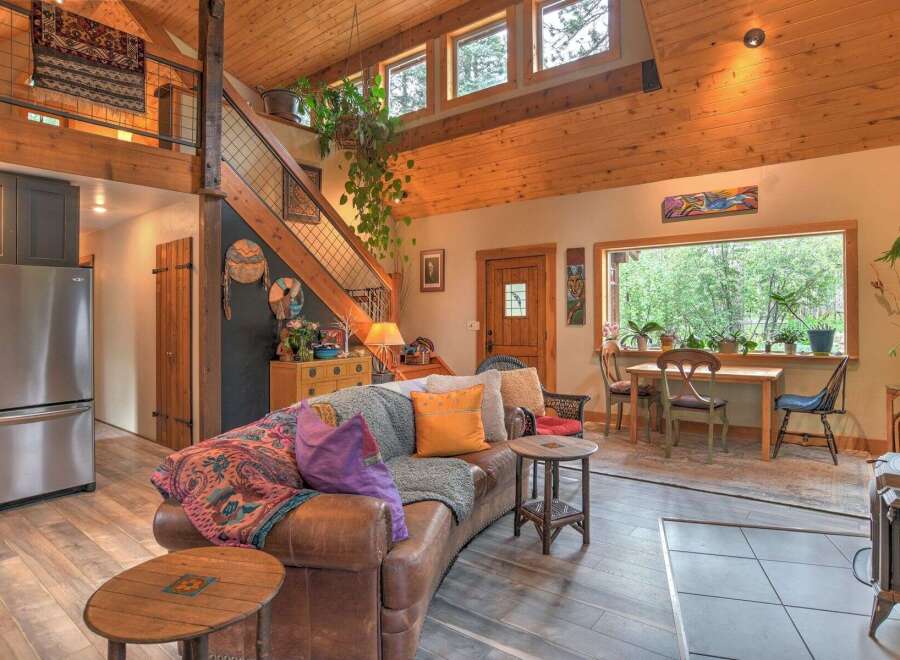 Experience rustic charm in this inviting living space, featuring a plush leather sofa adorned with colorful throws and pillows.